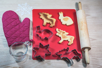 Cookie cutters and homemade cookies on the wooden table