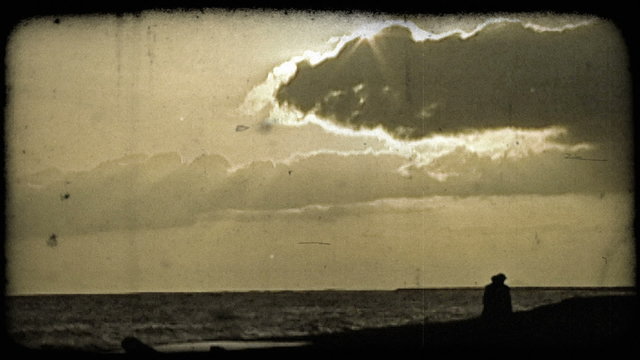 People on beach at sunset. Vintage stylized video clip.