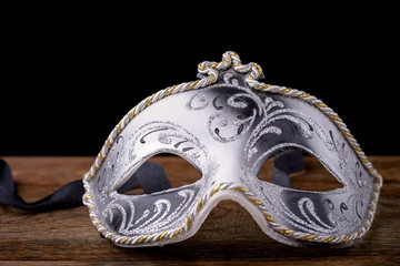 Venetian mask carnival white, black and gold on wood on a black background
