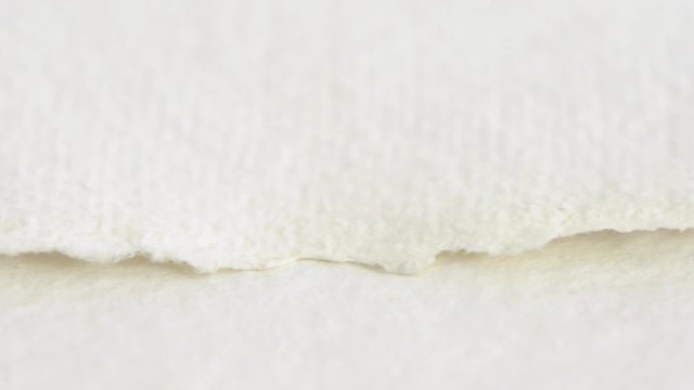 Close up of empty white paper with torn edges and texture. Slow sliding motion. Blank textured background for text.