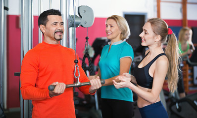Active smiling people  weightlifting training in health club