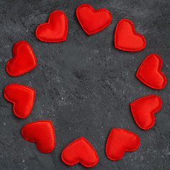 black background with a round frame of red hearts, closeup