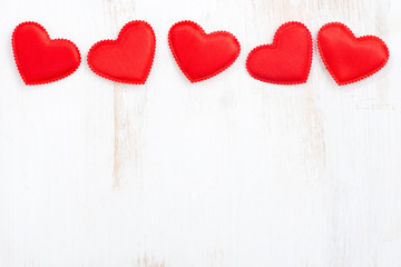 white wooden background with red hearts