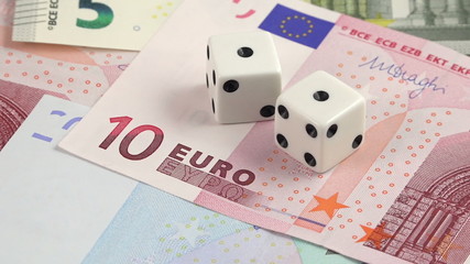 Dices on euro banknotes swiftly rotating under studio lighting symbolizing the risk factor on investments to europe. (1:1 version) - Powered by Adobe