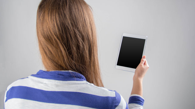 Frau hält ein Smartphone / Tablet mit leerem Display 