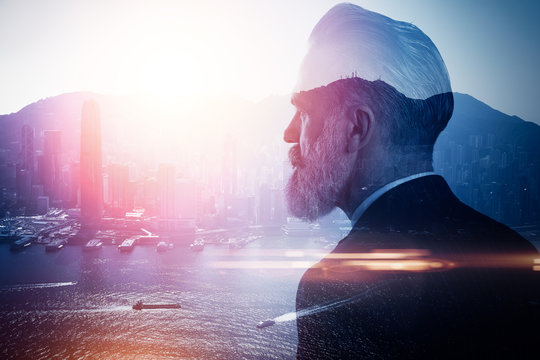 Double exposure of bearded businessman and contemporary city on the background. Horizontal