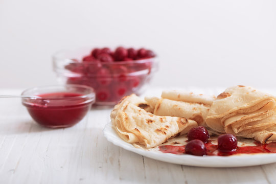 pancakes with  cherries on white wooden table