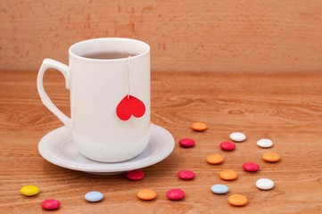 Cup of tea with heart shape on wooden table