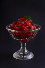 salad with beets and potatoes in a glass vase on a black background