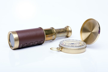 Old spyglass and compass on white background