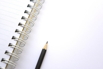 Pencil and notebook on white background