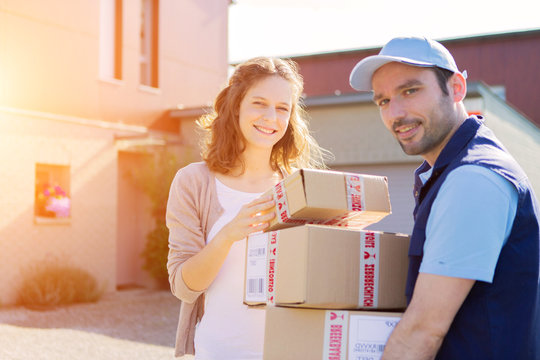 Young attractive woman receiving parcel at home
