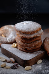 Gingerbread cookies dusted with icing sugar on a wooden table