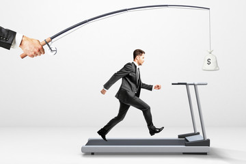 Reach a goal concept with businessman running on a treadmill for