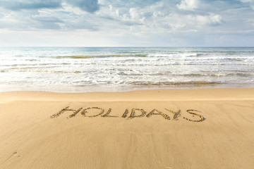 Fototapeta premium Writing in the sand. Family vacation in southern resorts.
