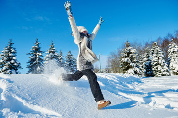 happy girl jumping into snow in winter