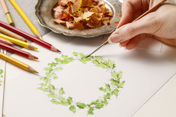 Woman drawing christmas wreath - step by step