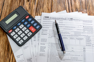 Tax form 1040 with pen and calculator on the table