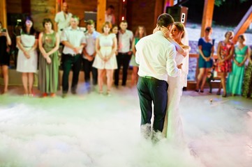 Obraz na płótnie Canvas Amazing first wedding dance on heavy smoke