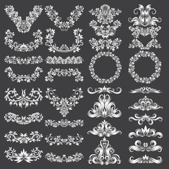 Big set of ornamental elements for design. White floral decorations on black. Isolated tattoo patterns in vintage style.