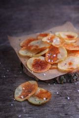 homemade potato chips with sea salt on a gray wooden background