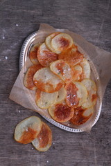 homemade potato chips with sea salt on a gray wooden background