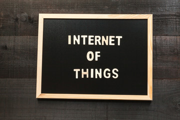 Wooden letters on slate and wood background with a concept message about the internet of things and classic male and female and diversity