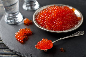 Red salmon caviar on black background