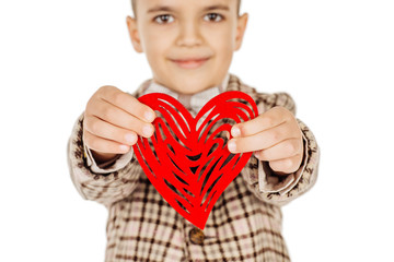 Smiling boy holding a red heart on his hand isolated on a white