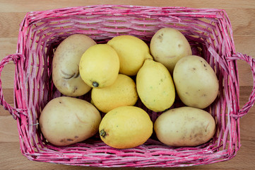 patate e limoni in un cestino rosa, vista dall'alto