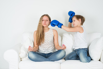 Girl meditating boy in boxing gloves wants to hit him