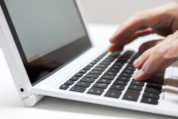Closeup of businessmen hand typing on laptop keyboard