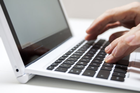 Closeup of businessmen hand typing on laptop keyboard