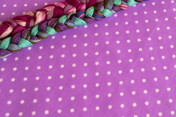 Embroidery threads of different colors on a purple background 