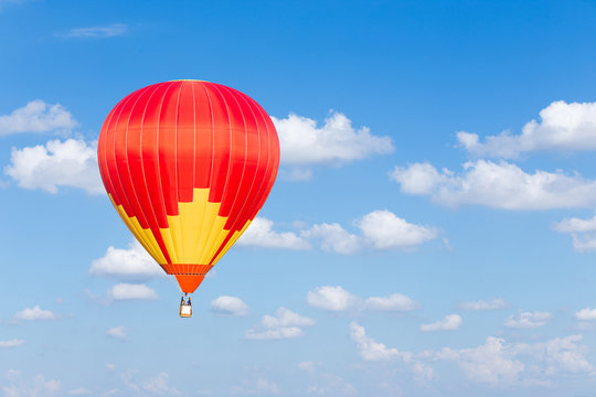 Red hot air balloon on blue sky background