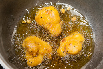 Closeup of cauliflower pakoras frying in oil