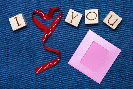 Ribbon heart, love inscription on wooden cubes, photo frame and