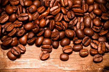 Coffee beans on a old wooden table for background. Space for tex