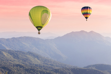 Hot air balloon above high mountain at sunset