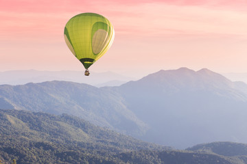 Hot air balloon above high mountain at sunset