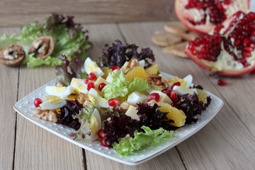 salad with quail eggs, cheese, pomegranate, orange