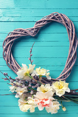 Yellow daffodils, willow branches  and decorative  heart  on tur