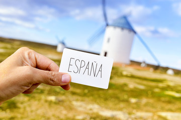 man shows a signboard with the word Espana, Spain, in front of t