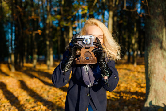 Hipster girl with vintage camera. modern hipster girl photographed using vintage camera. Outdoors lifestyle