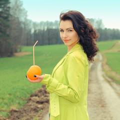 outside portrait of beautiful young curly woman with eyes shut with red apple in park. Young woman...