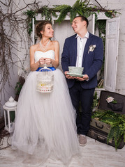 Young wedding couple posing in white decorating studio