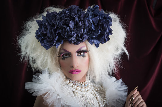 Drag queen with spectacular makeup, glamorous trashy look, posing happily and charming camera