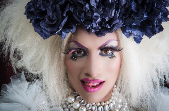 Closeup drag queen wearing spectacular makeup, glamorous trashy look, posing with open mouth for camera