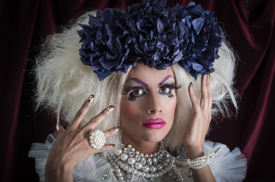 Drag queen with spectacular makeup, glamorous trashy look, posing while using hands and fingers