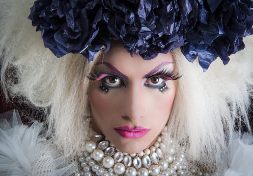 Drag queen with spectacular makeup, glamorous trashy look, posing serious facial expression